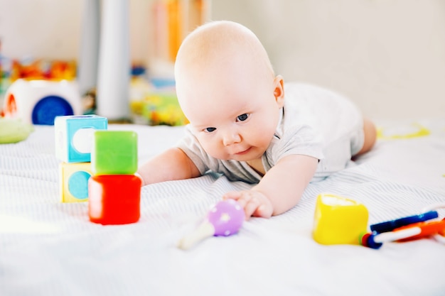 Baby playing with colorful toys at home Happy 6 months old baby child playing and discovery