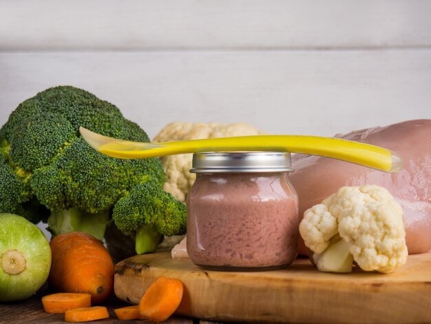 Baby puree from fresh zucchini, poultry and broccoli in a jar. baby food.