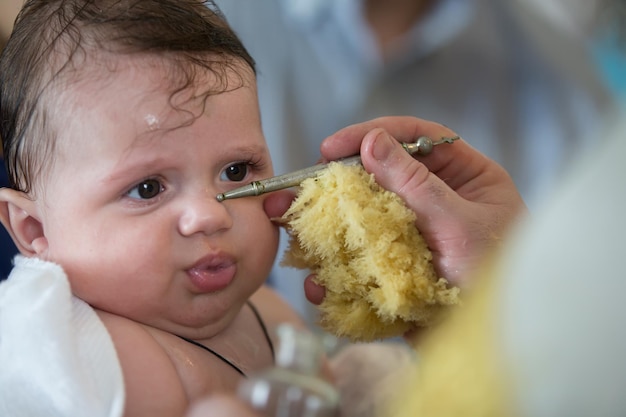 Baby at the rite of baptism Accepting faith Religious process of child baptism