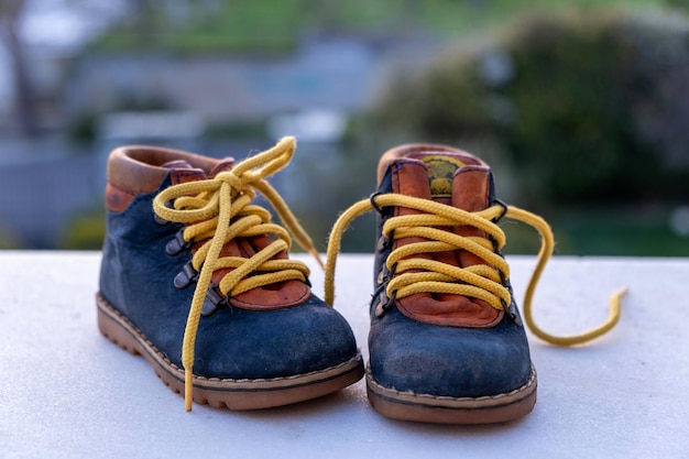 Baby shoes outdoors on blur nature background closeup view