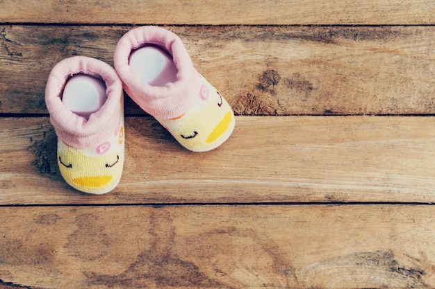 Photo baby shoes on wooden background with space