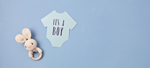 Baby shower gender reveal party It's a boy message over paper cut onesie