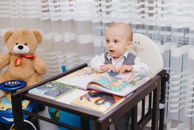 A baby sits in a high chair with a book that says'the little prince '