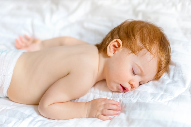 Baby sleeps on a white bedspread clean and minimalistic