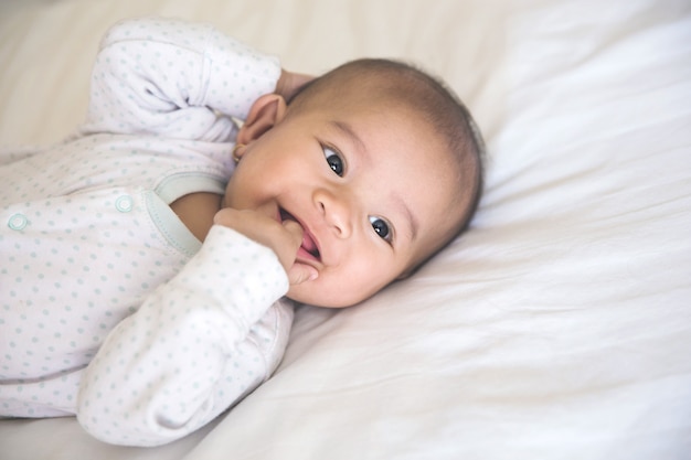 Baby smiling lying on a bed