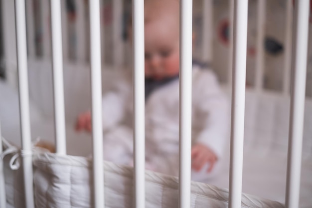 Baby stay alone in crib frame help for kids adoption concept photo