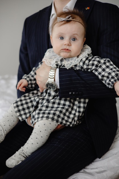 A baby in a suit holds a baby.