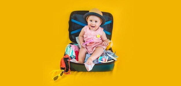 Baby and suitcase with things luggage travel concept Going on vacation at sea Selective focus