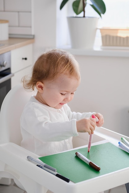 Baby toddler drawing his first scribbles using colored felttip pens Drawing development in kids