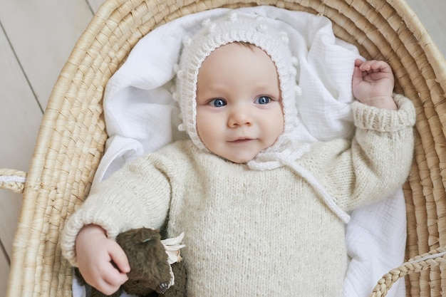 Baby in wicker cradle with wooden toy Mothers Day Children Protection Day Cheerful child happy childhood