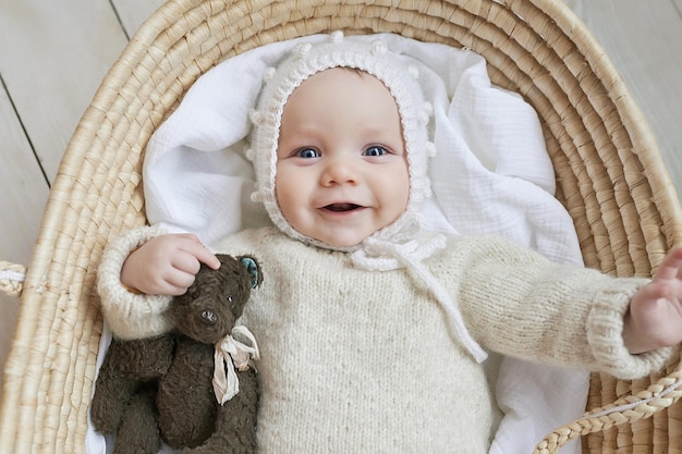 Baby in wicker cradle with wooden toy Mothers Day Children Protection Day Cheerful child happy childhood