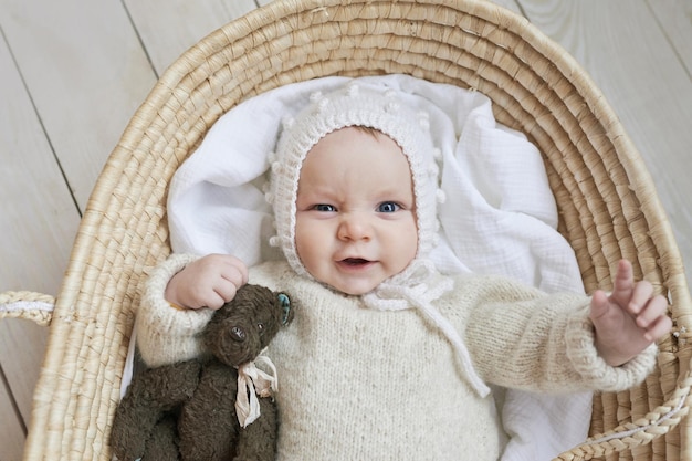 Baby in wicker cradle with wooden toy Mothers Day Children Protection Day Cheerful child happy childhood