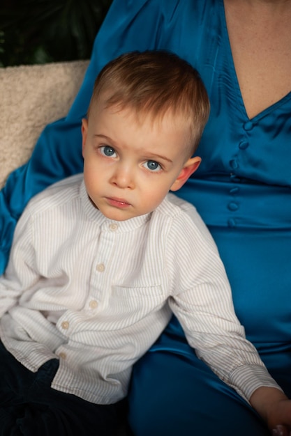 a baby with blue eyes is sitting on the carpet