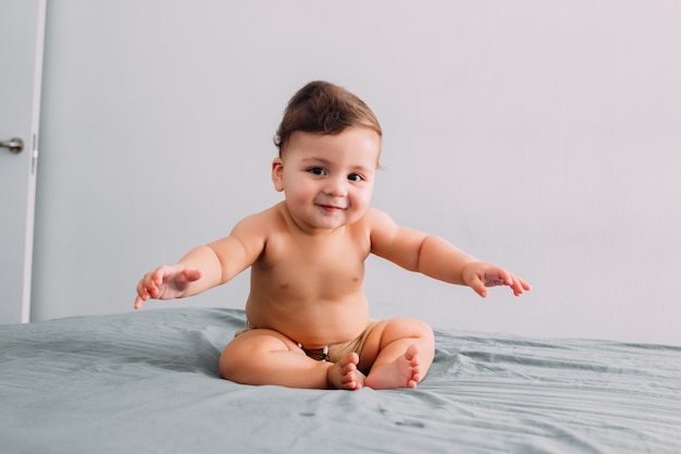 Baby with funny face sitting on the bed, face expression