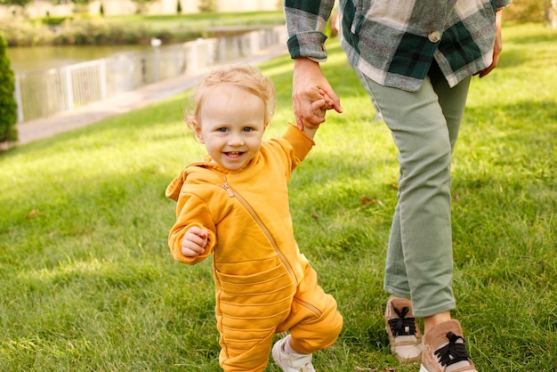 Photo baby with mom for a walk in the park in autumn