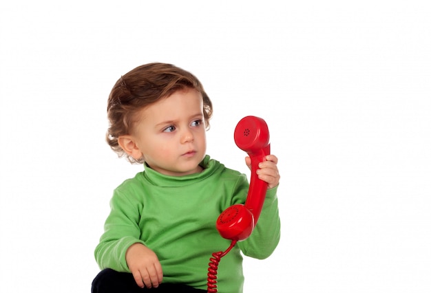 Baby with one years old playing with a red phone