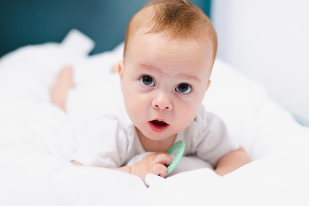 A baby with a teether on a white background Teething Children's article