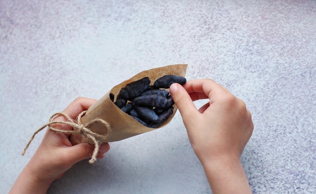 Baby39s hands with paper bag with honeysuckle berry