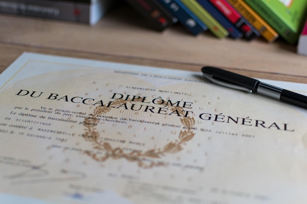 Baccalaureate close up of a french diploma with some books the text means general baccalaureate diploma