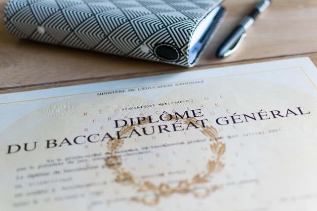 Baccalaureate close up of a french diploma with some books the text means general baccalaureate diploma