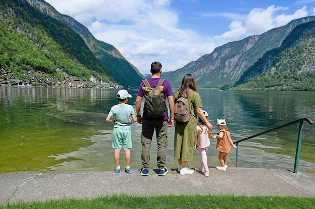 Back of family with three children over Austrian alps lake in Hallstatt Salzkammergut Austria