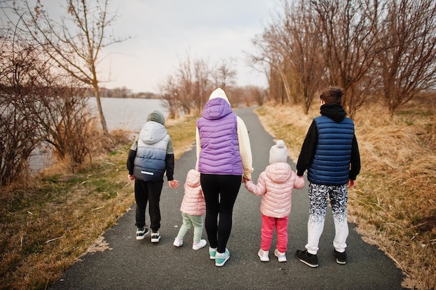 Back of mother walking with kids on the path by the lake