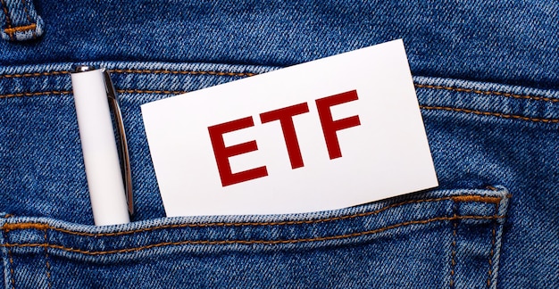 The back pocket of blue jeans contains a white pen and a white card with the text ETF Exchange Traded Funds