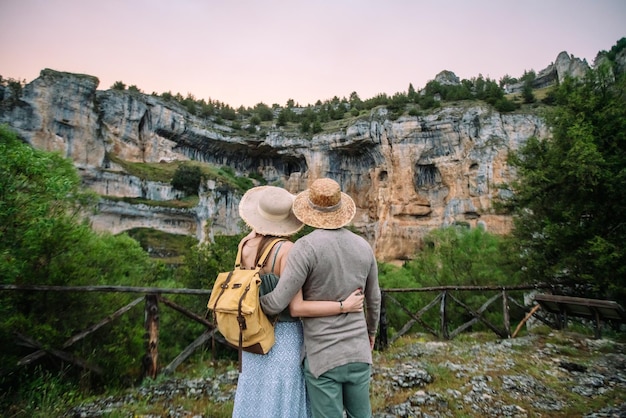 Back rear view of unrecognizable couple in love traveling in countryside. Horizontal view of young couple sightseeing in the river Lobos canyon. People traveling in spanish travel destinations.