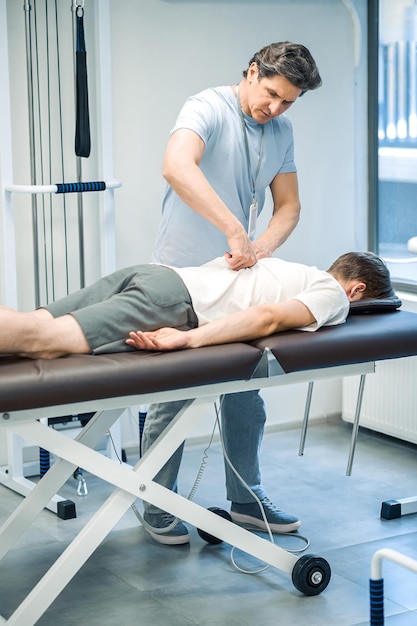 Back rehabilitation Manual therapist working with patient back and looking involved