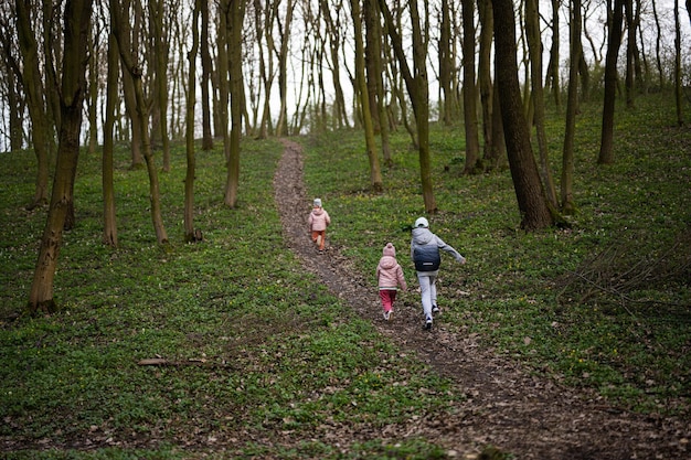 Back of running kids in spring forest path Happy childhood moments