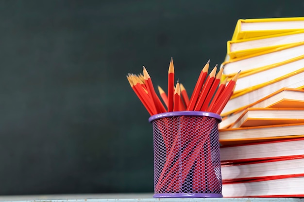 Back to the school background with a book a red pencil box on the blackboard an empty space can put text