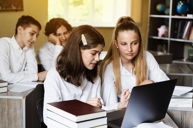 Back to school Children study online on laptop and communicating with classmates online at geography lesson and discuss different countries with globe