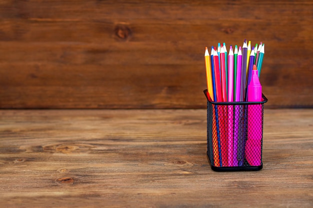 Back to school. Colored pencils in an organizer on wood.Copy space.