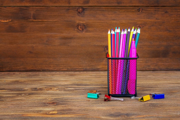 Back to school. Colored pencils in an organizer on wood.