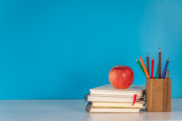 Back to school concept.Apple and school supplies  on white table