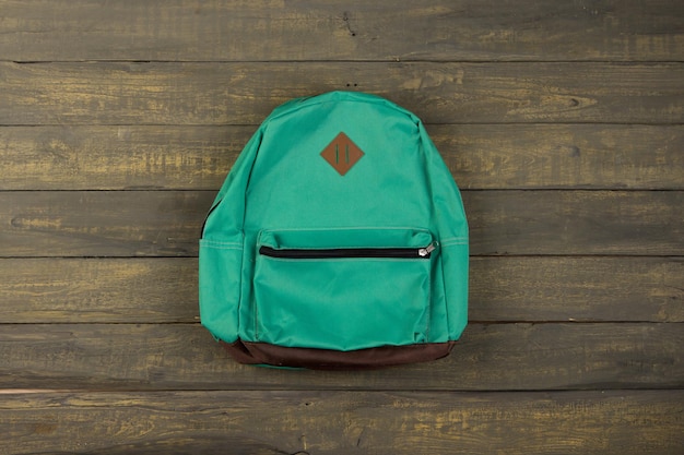 Back to school concept blue backpack on wooden backgroung