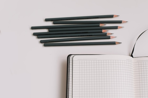 Back to school concept school or office supplies notebook and pencils on white background top view