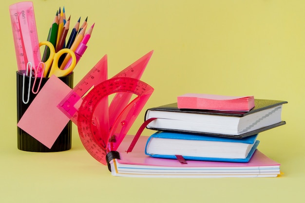 Back to school concept with space for text. Copy space. School office supplies.Creative desk with colourful stationery. Colored paper clip.School supplies on yellow background.Office desk