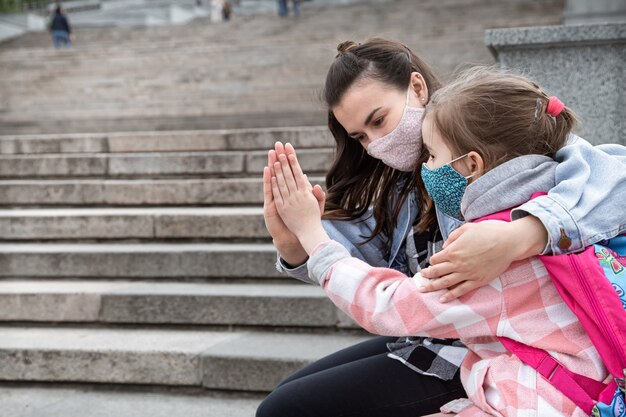 Back to school. Coronavirus pandemic children go to school in masks. Friendly relations with mother. Child education.