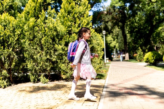 Back to school Cute child girl with backpack running and going to school with fun