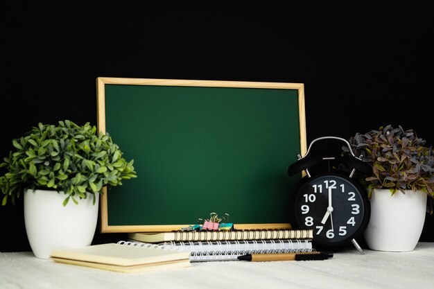 Back to school and education concept, green chalkboard with pile of notebook paper