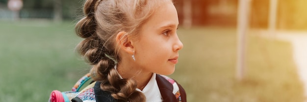 Back to school face portrait little happy kid pupil schoolgirl eight year old in fashion uniform with backpack and hairstyle braid ready going second grade first day primary school banner flare