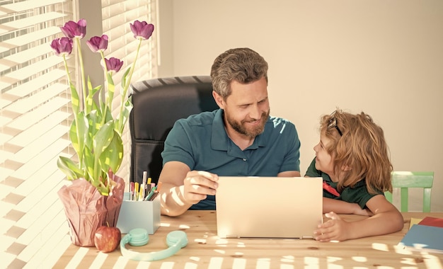 Back to school father and son use communication technology at home