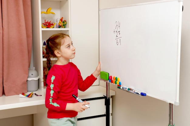 back to school girl solves house example on blackboard