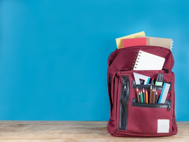 Back to school . school bag and supplies on blue  