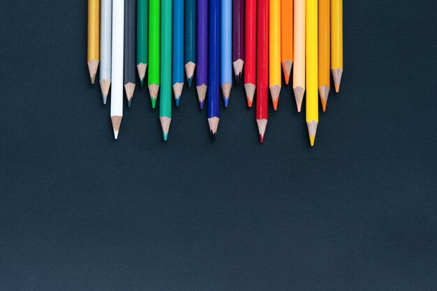 Back to school shot of color pencil pile pencil nibs on black background