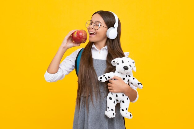 Back to school Teenager schoolgirl hold toy School children with favorite toys on isolated yellow studio background