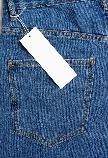 Back side pocket of blue jeans pants and price tag closeup background mockup copy space