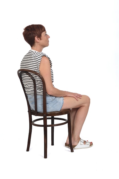 Back and side view of middle aged woman sitting on chair on white background