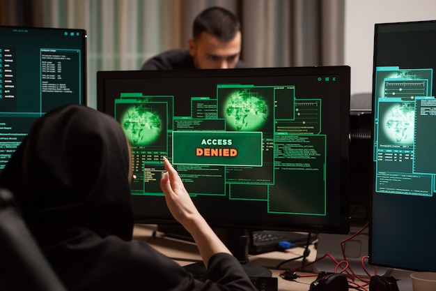 Back view of angry female hacker after access denied showing on computer desktop.